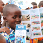 Children smile with HALO leaflets from a risk education session